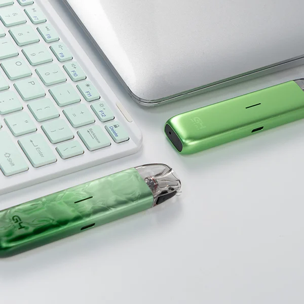 Uwell Caliburn G4 Mini Pod Kit in zwei Grüntönen neben Laptop und Tastatur